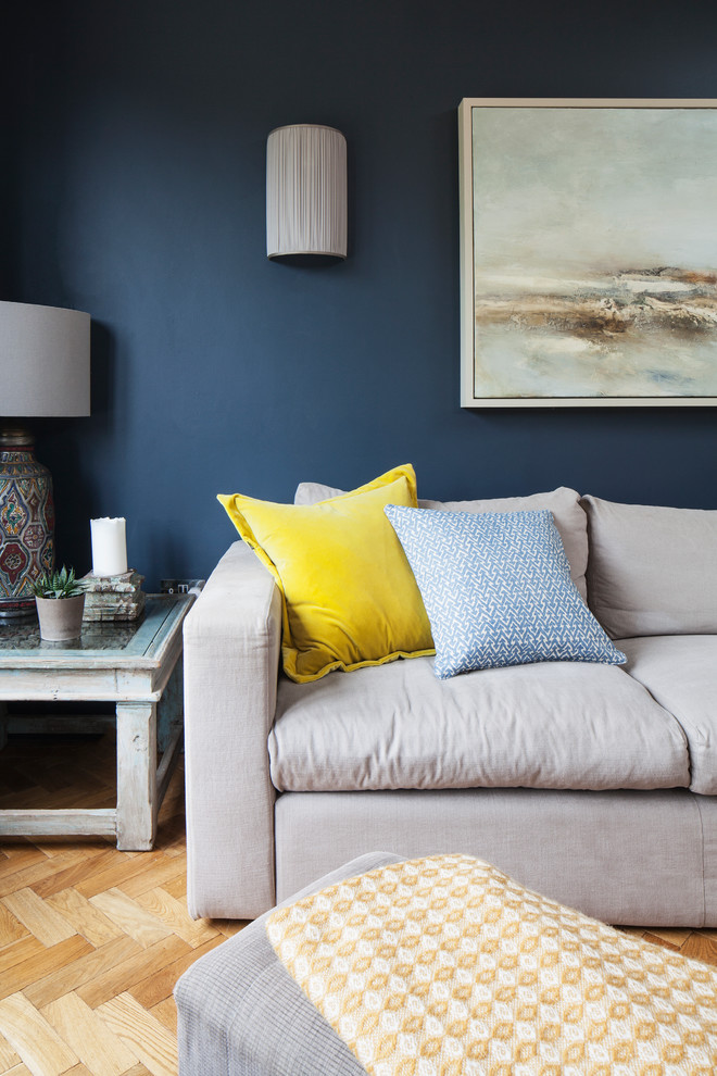 サセックスにある高級な広いトランジショナルスタイルのおしゃれなLDK (青い壁、淡色無垢フローリング、薪ストーブ、タイルの暖炉まわり、茶色い床、三角天井) の写真