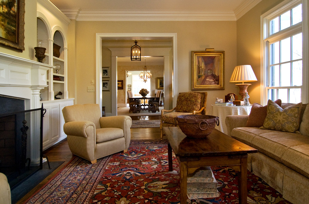Immagine di un soggiorno chic di medie dimensioni e chiuso con sala formale, pareti beige, pavimento in legno massello medio, camino classico e nessuna TV
