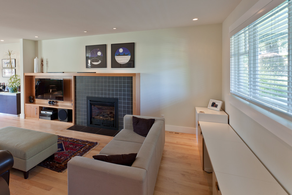 Modernes Wohnzimmer mit hellem Holzboden, Kamin und gefliester Kaminumrandung in Vancouver