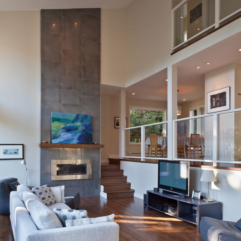 На фото: открытая гостиная комната среднего размера в современном стиле с белыми стенами, паркетным полом среднего тона, подвесным камином, фасадом камина из плитки, отдельно стоящим телевизором и коричневым полом