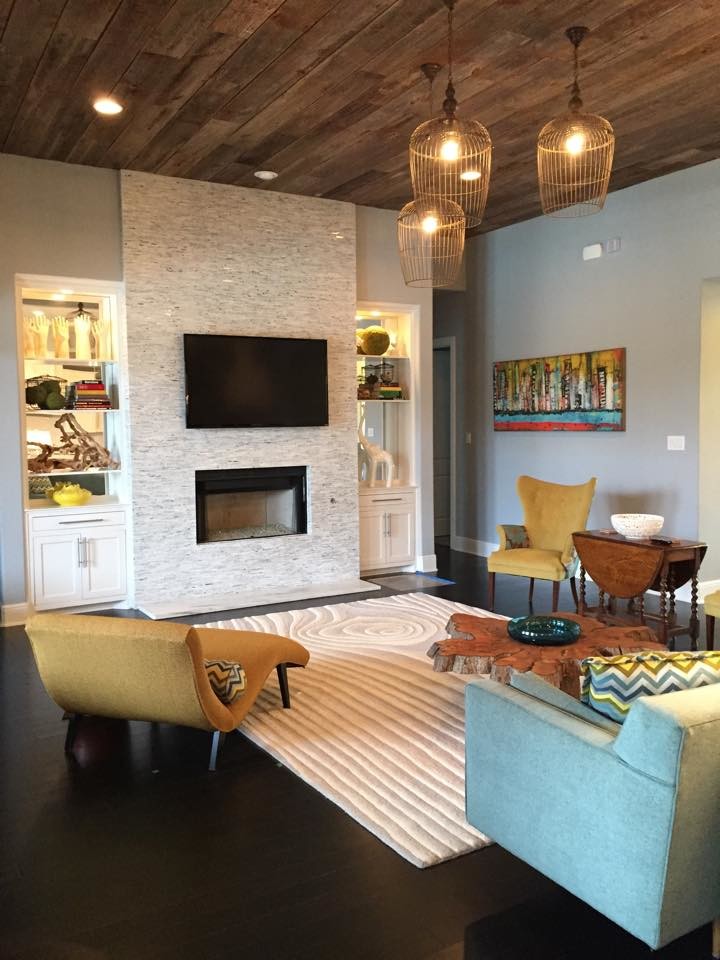 Großes, Offenes Modernes Wohnzimmer mit grauer Wandfarbe, dunklem Holzboden, Kamin, Kaminumrandung aus Stein und TV-Wand in Dallas