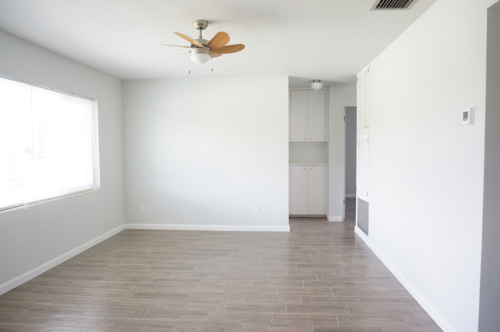Exempel på ett litet retro allrum med öppen planlösning, med ett finrum, grå väggar, klinkergolv i porslin, en fristående TV och brunt golv