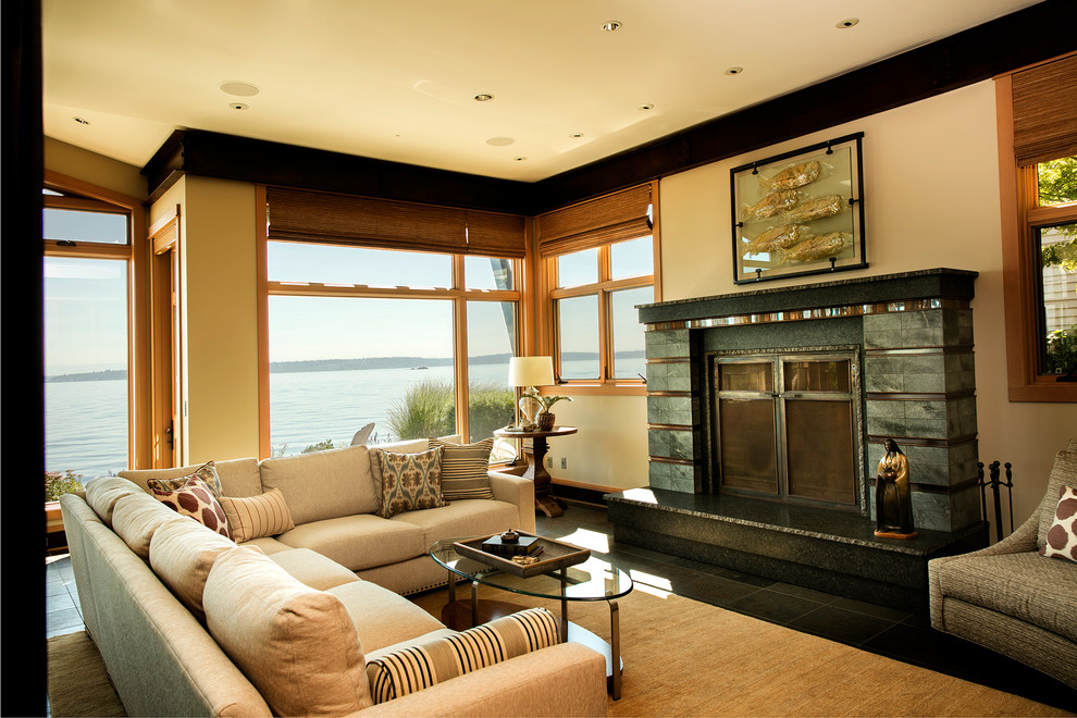 シアトルにある高級な中くらいなビーチスタイルのおしゃれなリビング (ベージュの壁、スレートの床、標準型暖炉、タイルの暖炉まわり、テレビなし、グレーの床) の写真