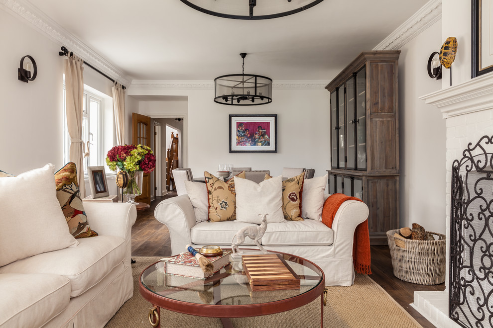 Kleines, Repräsentatives, Abgetrenntes Landhaus Wohnzimmer mit beiger Wandfarbe, dunklem Holzboden, Kaminofen, Kaminumrandung aus Backstein und braunem Boden in Buckinghamshire