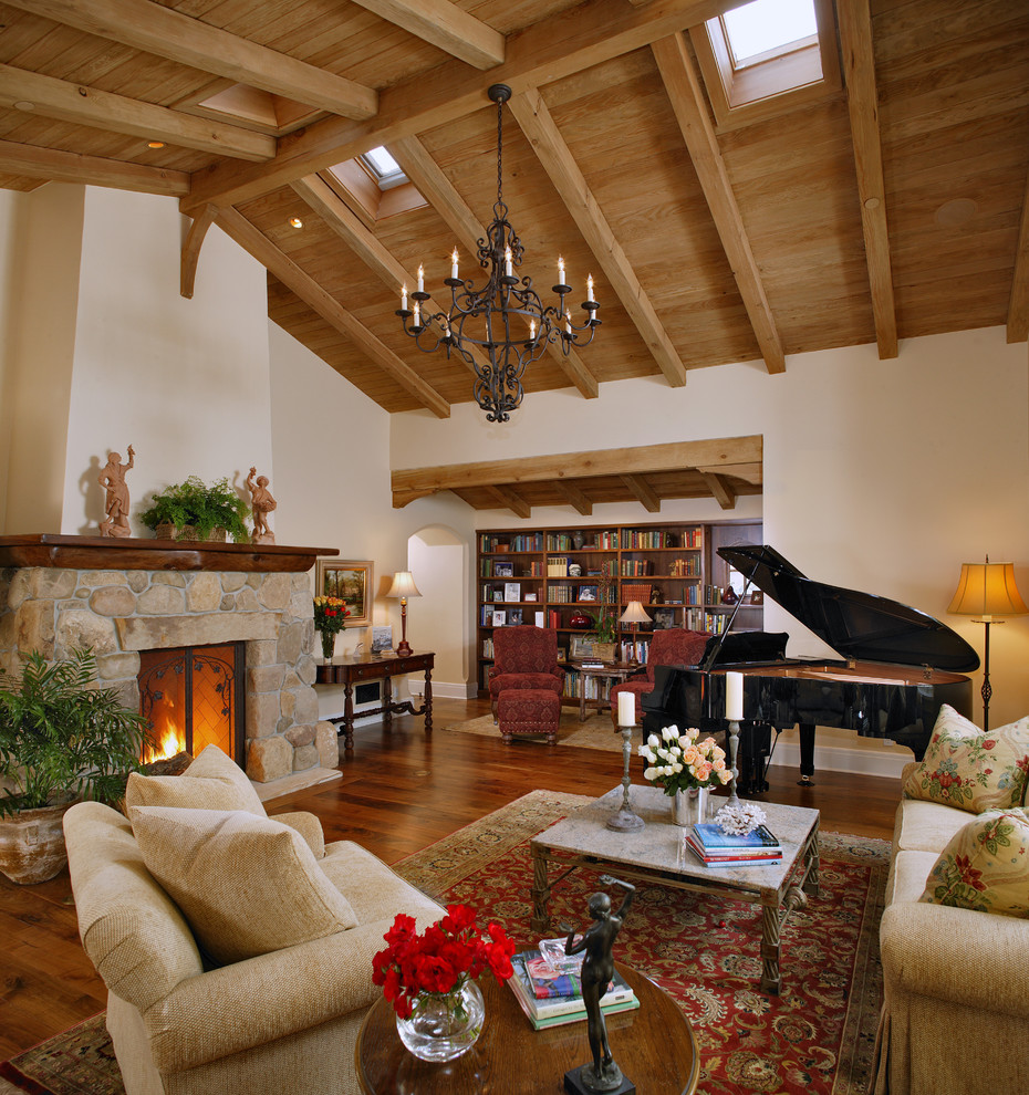 На фото: гостиная комната в классическом стиле с музыкальной комнатой, фасадом камина из камня и коричневым полом с
