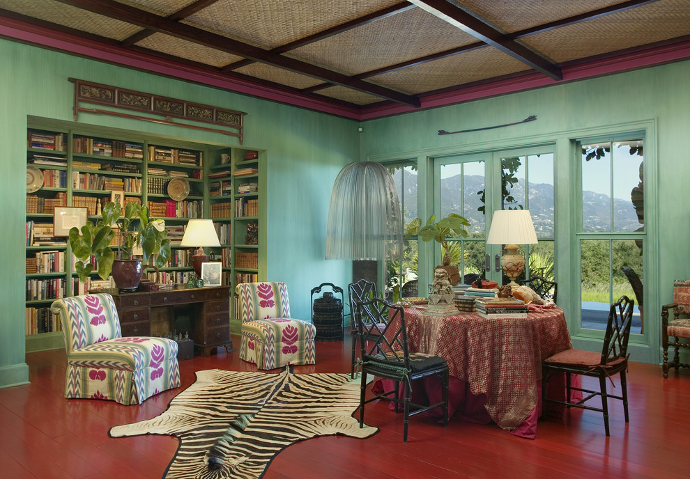Imagen de biblioteca en casa bohemia con paredes verdes y suelo rojo