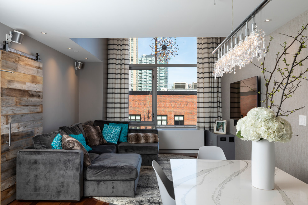 Idee per un piccolo soggiorno design aperto con pareti grigie, pavimento in laminato, TV a parete e pavimento marrone