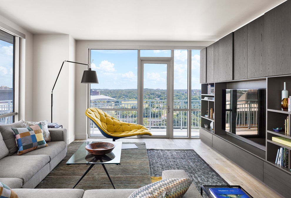 Immagine di un soggiorno minimal di medie dimensioni con parquet chiaro e parete attrezzata