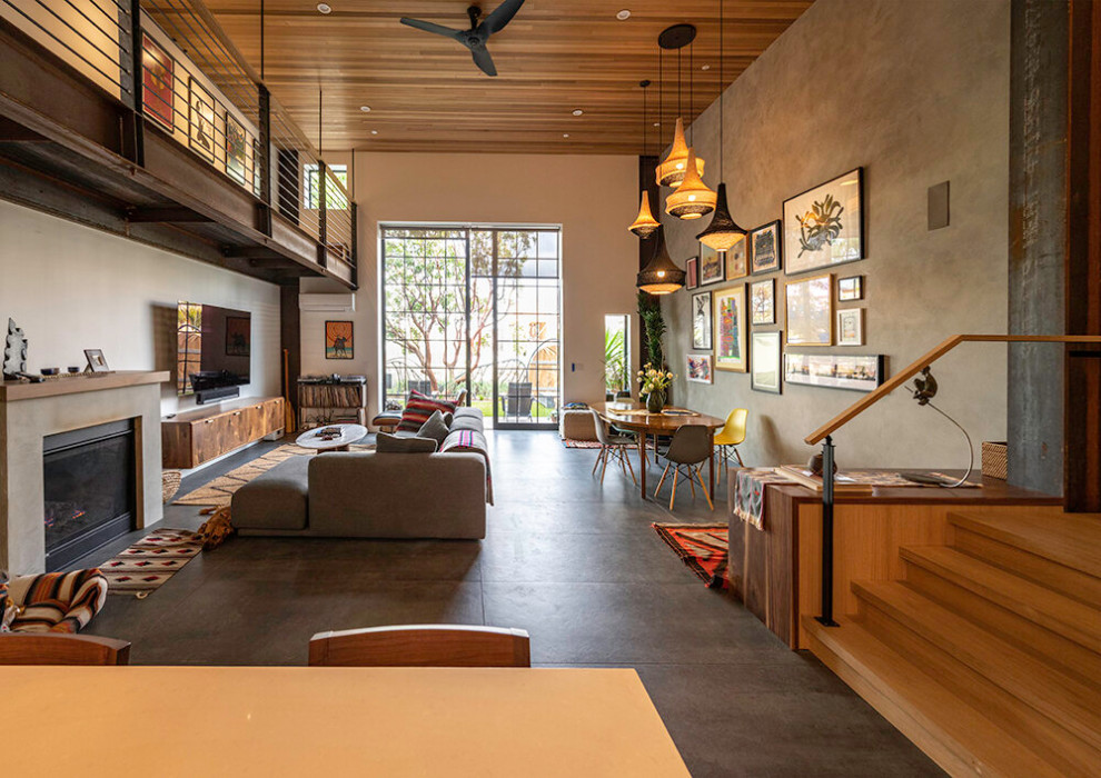 Foto di un grande soggiorno minimalista aperto con camino classico, TV a parete e pavimento grigio