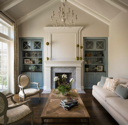 traditional living room with blue built in bookshelves and cream color scheme