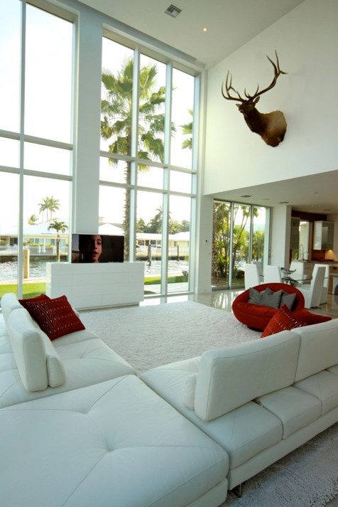 Imagen de salón para visitas abierto moderno grande sin chimenea con paredes blancas, televisor retractable y suelo de mármol