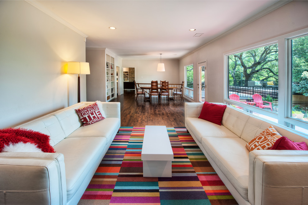 This is an example of a medium sized modern open plan living room in Austin with grey walls and medium hardwood flooring.