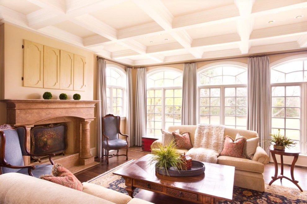 Example of a large classic formal and open concept medium tone wood floor and brown floor living room design in Chicago with beige walls, a standard fireplace, a plaster fireplace and no tv