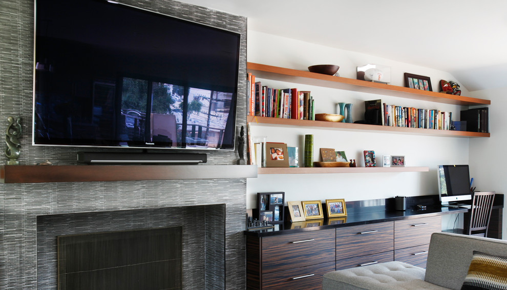 Стильный дизайн: изолированная гостиная комната среднего размера в современном стиле с белыми стенами, стандартным камином и телевизором на стене - последний тренд