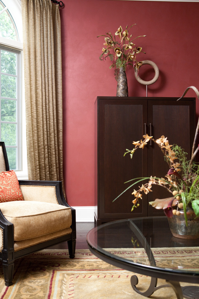 Пример оригинального дизайна: большая парадная, открытая гостиная комната в классическом стиле с красными стенами, темным паркетным полом и коричневым полом