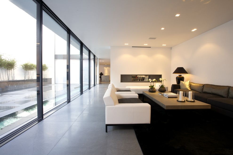 Идея дизайна: гостиная комната в стиле модернизм с белыми стенами, двусторонним камином и серым полом