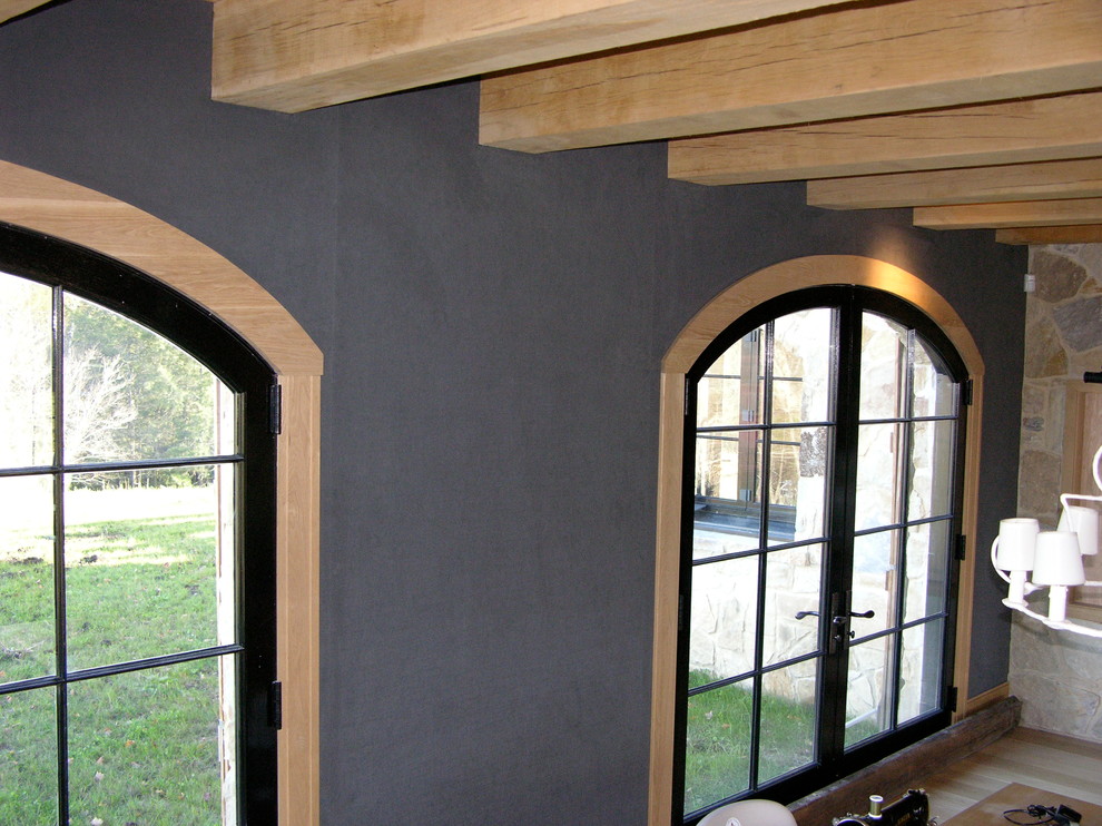 Ejemplo de salón para visitas abierto ecléctico grande con paredes grises, suelo de madera clara y televisor colgado en la pared
