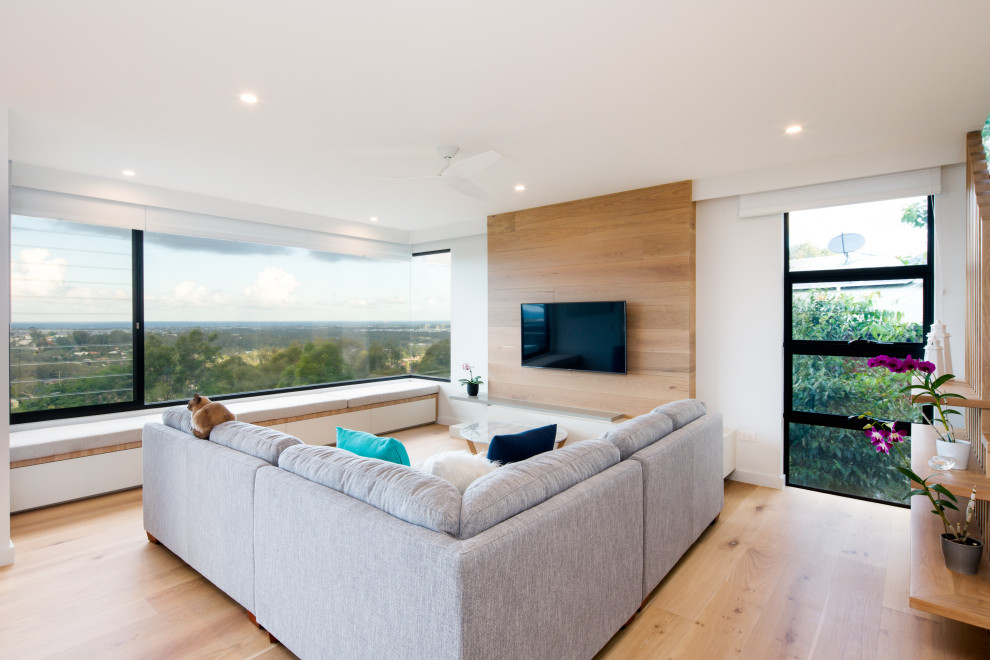 Idee per un grande soggiorno design chiuso con sala formale, TV a parete, pareti bianche, parquet chiaro e pavimento marrone