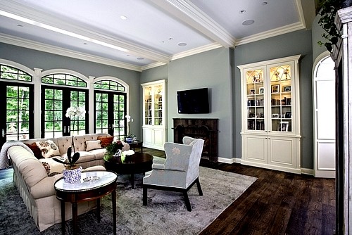 Стильный дизайн: огромная изолированная гостиная комната в классическом стиле с синими стенами, темным паркетным полом, стандартным камином, фасадом камина из камня и телевизором на стене - последний тренд