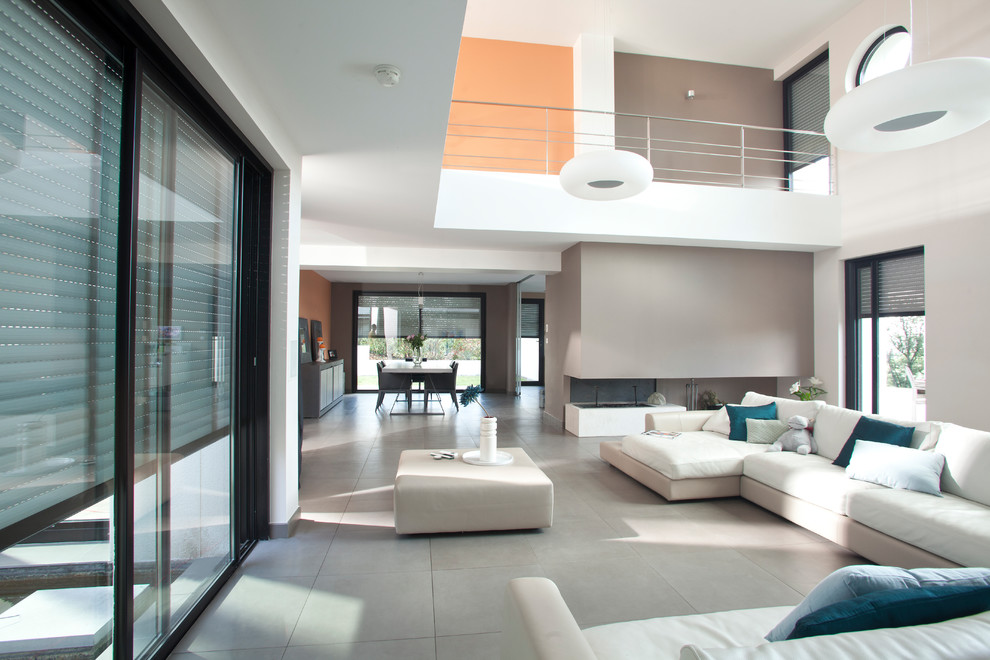 Ispirazione per un ampio soggiorno minimalista aperto con pareti multicolore e pavimento grigio