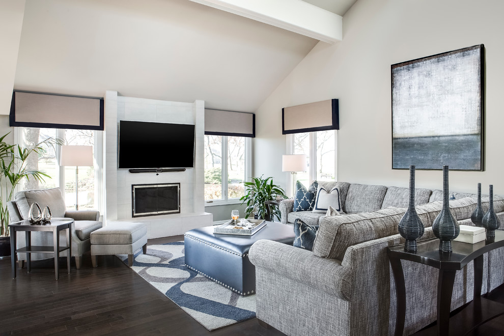 This is an example of a large traditional open plan living room in Kansas City with grey walls, dark hardwood flooring, a standard fireplace, a tiled fireplace surround and a wall mounted tv.