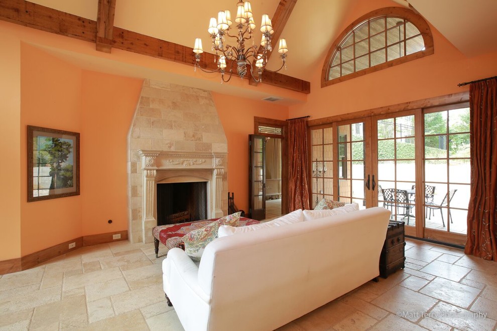На фото: изолированная гостиная комната среднего размера в классическом стиле с полом из керамической плитки, стандартным камином, фасадом камина из штукатурки и оранжевыми стенами без телевизора