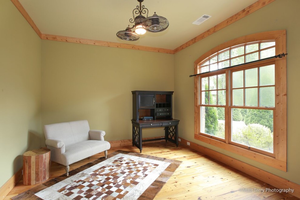 Mittelgroßes, Fernseherloses, Abgetrenntes Uriges Wohnzimmer ohne Kamin mit grüner Wandfarbe und hellem Holzboden in Sonstige