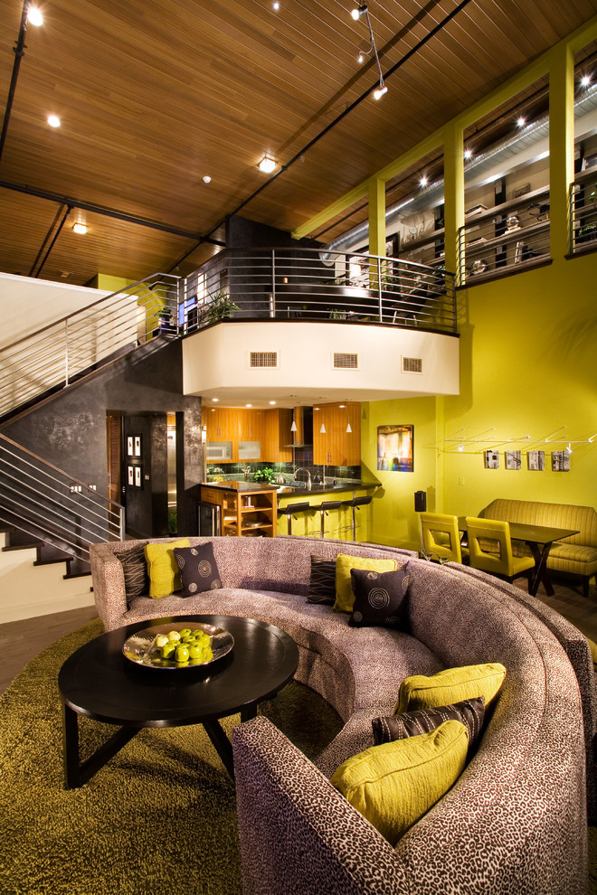 Cette photo montre un salon industriel avec un mur vert et un escalier.