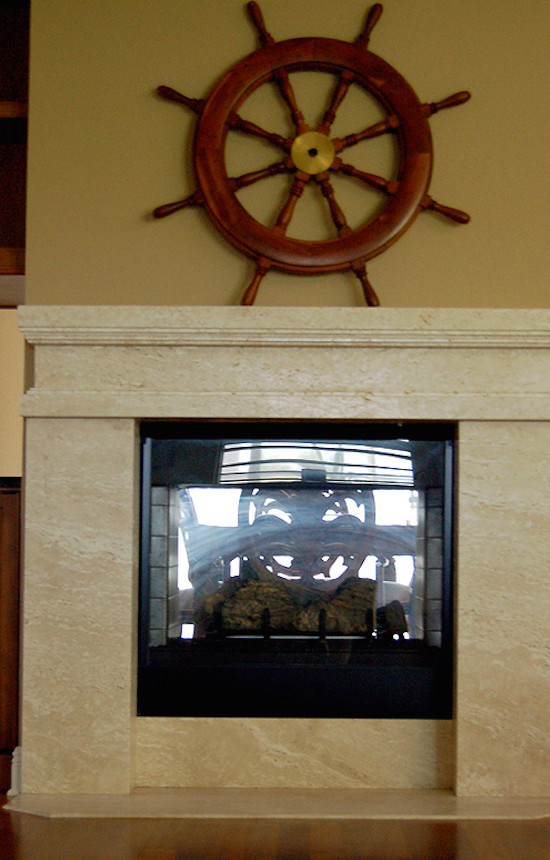 タンパにある高級な広いトロピカルスタイルのおしゃれなLDK (黄色い壁、無垢フローリング、両方向型暖炉、石材の暖炉まわり、テレビなし、茶色い床) の写真
