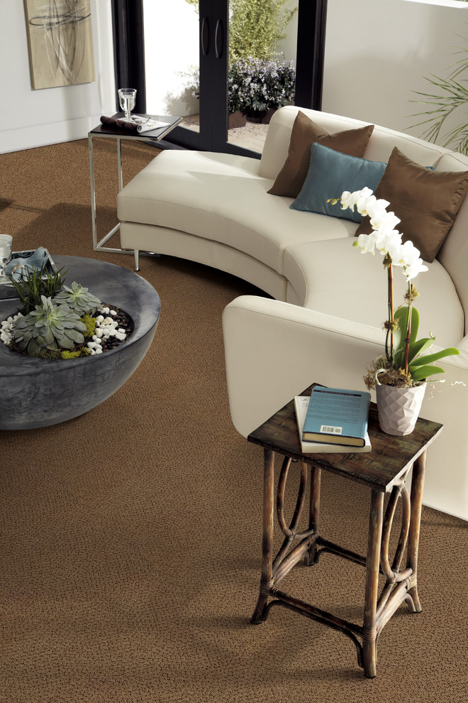 This is an example of a world-inspired open plan living room in Jacksonville with beige walls and carpet.