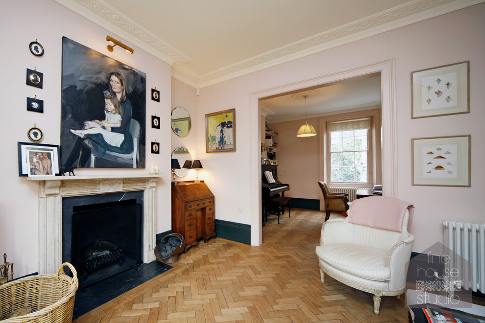 Foto de salón con rincón musical abierto clásico grande con paredes rosas, suelo de madera en tonos medios, todas las chimeneas y marco de chimenea de piedra