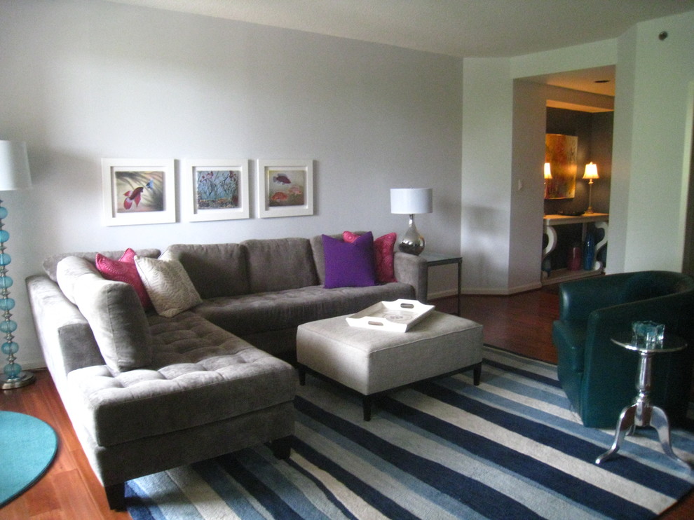 Foto di un grande soggiorno design aperto con pareti grigie e pavimento in legno massello medio