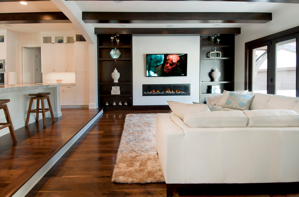 Exemple d'un grand salon chic ouvert avec un mur blanc, parquet foncé, une cheminée ribbon et un téléviseur fixé au mur.