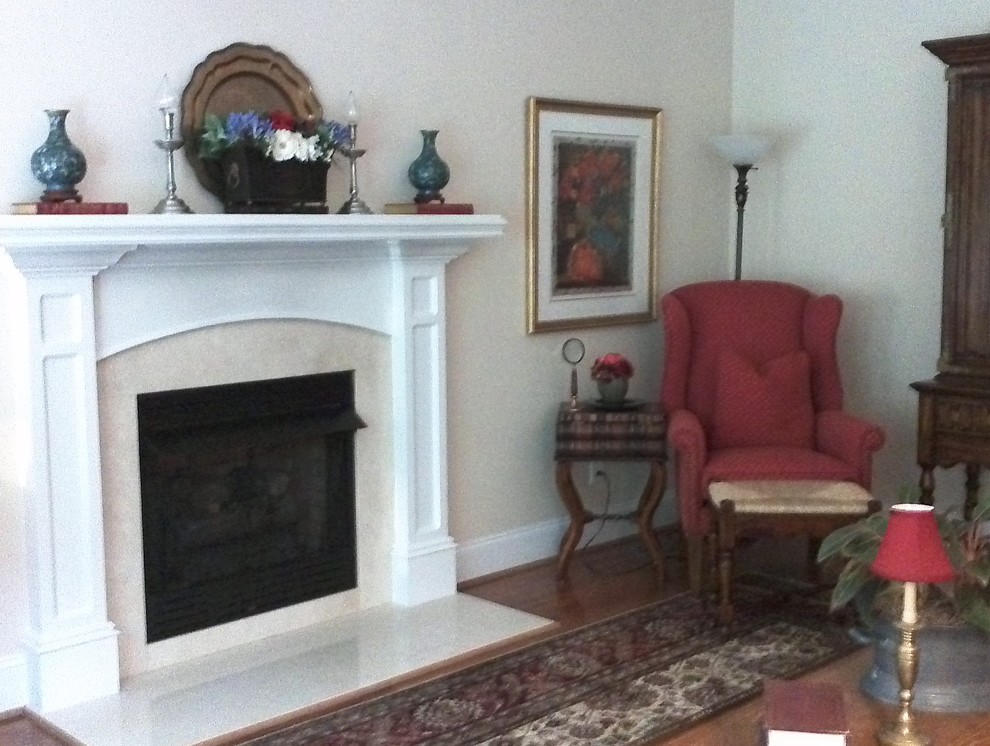 Foto di un soggiorno classico di medie dimensioni e chiuso con pareti beige, moquette, camino classico, cornice del camino in legno e TV nascosta