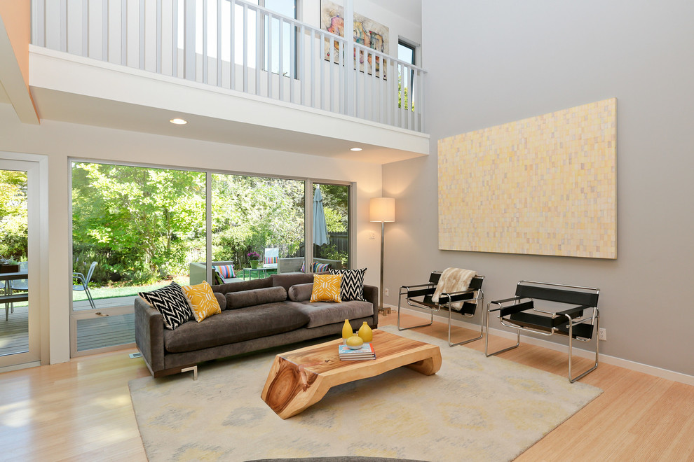Foto de salón actual sin chimenea y televisor con paredes grises, suelo de madera en tonos medios y suelo beige