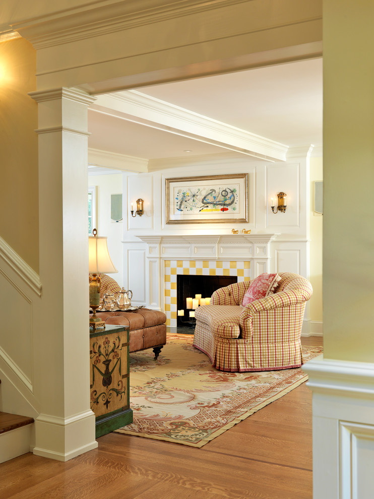 Repräsentatives, Fernseherloses Klassisches Wohnzimmer mit beiger Wandfarbe, hellem Holzboden, Kamin und gefliester Kaminumrandung in Boston