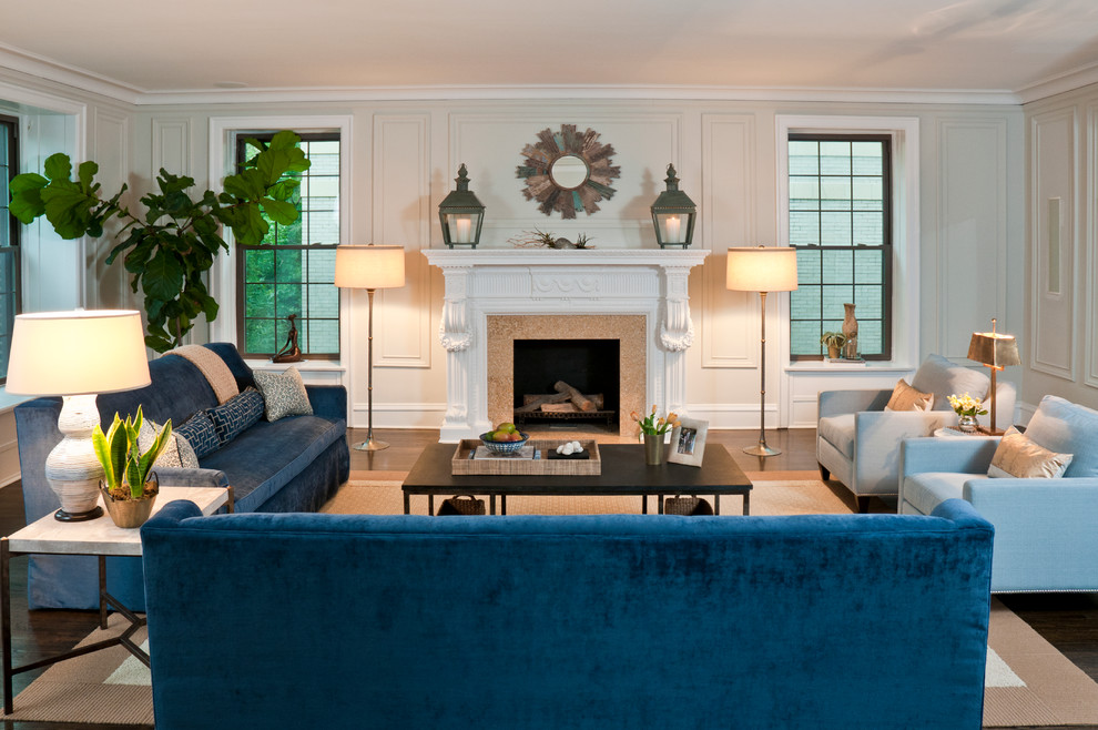 Свежая идея для дизайна: огромная открытая гостиная комната в стиле фьюжн с бежевыми стенами, стандартным камином, темным паркетным полом, фасадом камина из плитки и синим диваном - отличное фото интерьера