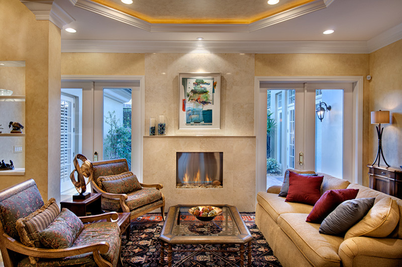 Modelo de salón abierto clásico renovado con paredes beige, chimeneas suspendidas y marco de chimenea de baldosas y/o azulejos