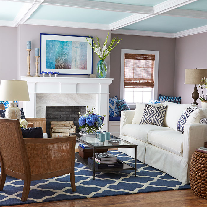 Klassisches Wohnzimmer mit lila Wandfarbe, braunem Holzboden, Kamin und Kaminumrandung aus Stein in Charlotte