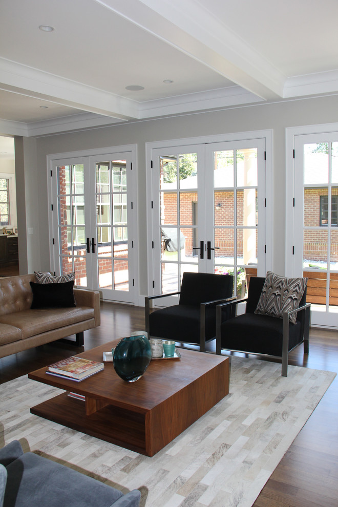Стильный дизайн: большая парадная, открытая гостиная комната в современном стиле с серыми стенами, паркетным полом среднего тона, стандартным камином, фасадом камина из камня и коричневым полом без телевизора - последний тренд
