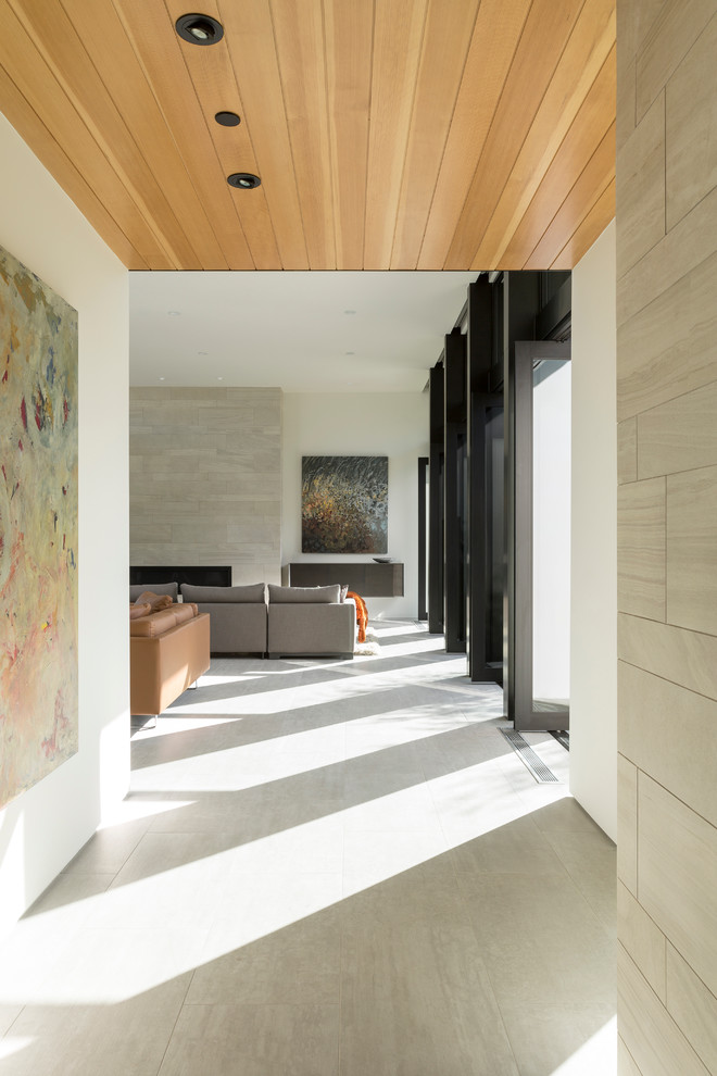 Example of a large minimalist open concept porcelain tile living room design in Los Angeles with white walls, a ribbon fireplace, a stone fireplace and a concealed tv