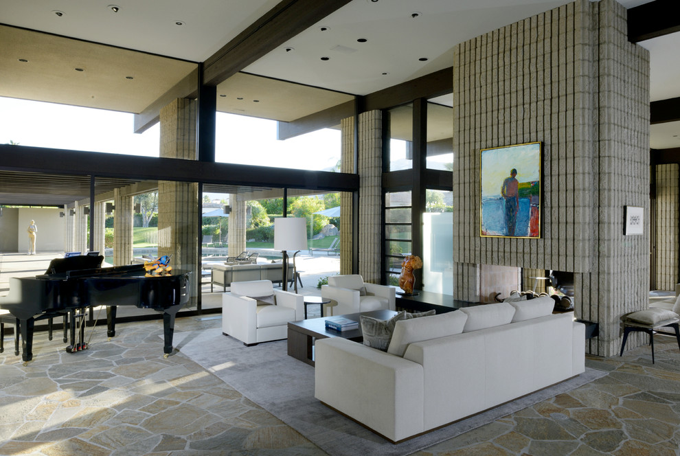 Offenes Modernes Wohnzimmer mit weißer Wandfarbe, Schieferboden, Tunnelkamin und Kaminumrandung aus Beton in Los Angeles