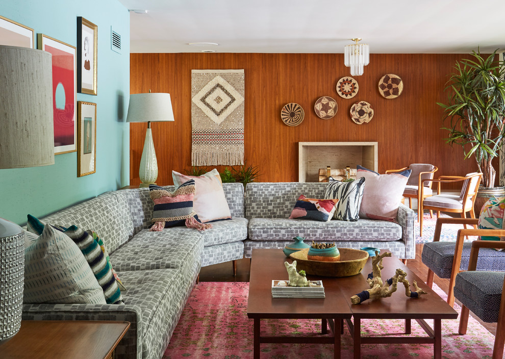 Offenes Wohnzimmer mit blauer Wandfarbe, braunem Holzboden, Kamin und braunem Boden in Chicago
