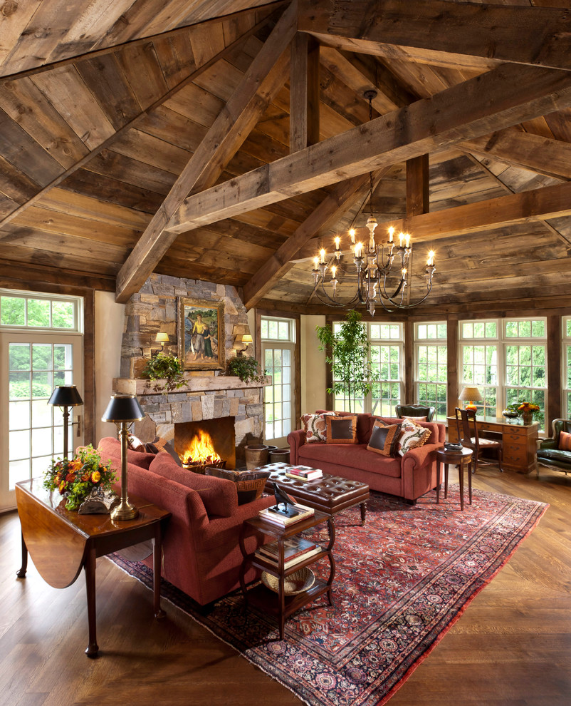 Rustic formal living room in Milwaukee with beige walls, medium hardwood flooring, a standard fireplace, a stone fireplace surround and brown floors.
