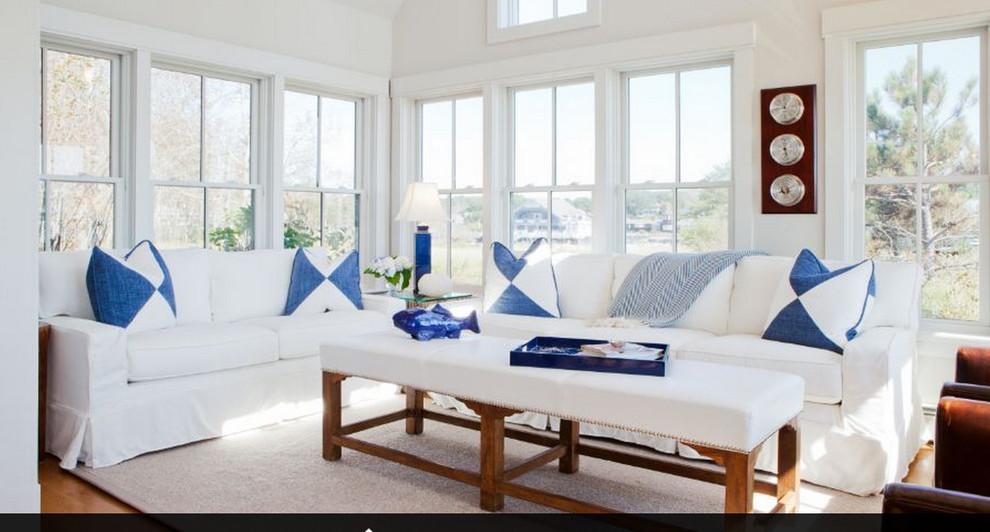 Design ideas for a medium sized beach style enclosed living room in Boston with white walls, light hardwood flooring, no fireplace, no tv and feature lighting.