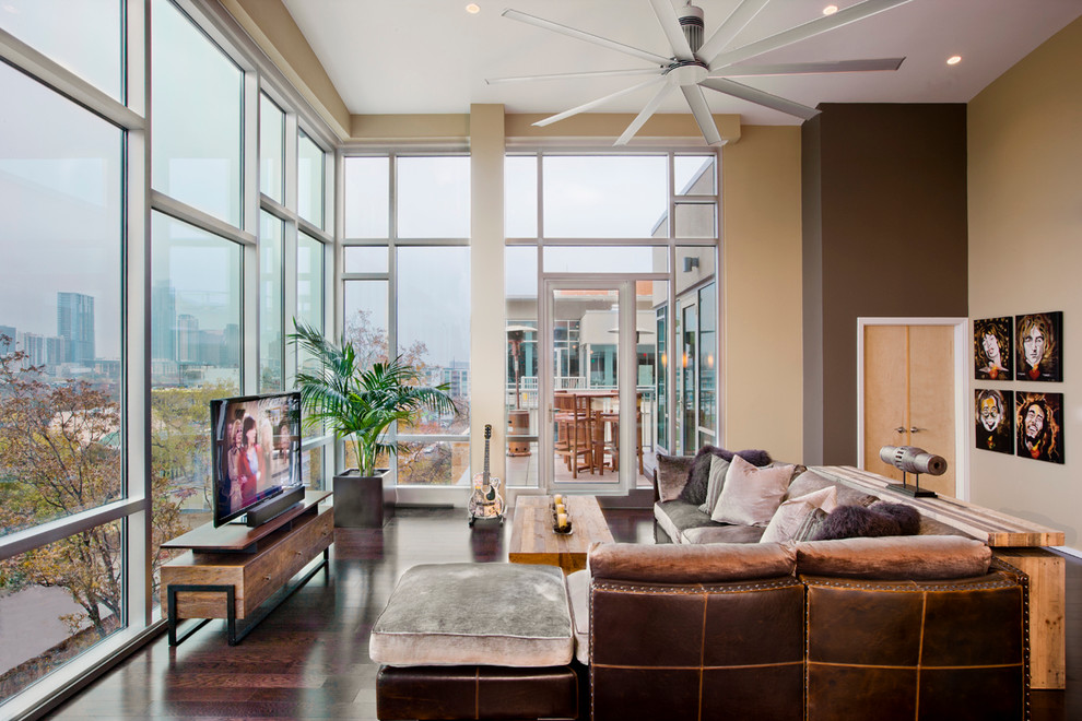 Großes, Repräsentatives, Offenes Modernes Wohnzimmer ohne Kamin mit brauner Wandfarbe, dunklem Holzboden, freistehendem TV und braunem Boden in Austin