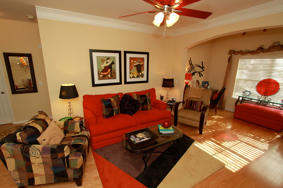 Example of an open concept light wood floor living room design in Tampa with beige walls