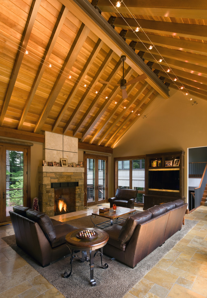 Свежая идея для дизайна: гостиная комната в стиле рустика с фасадом камина из камня и коричневым диваном - отличное фото интерьера