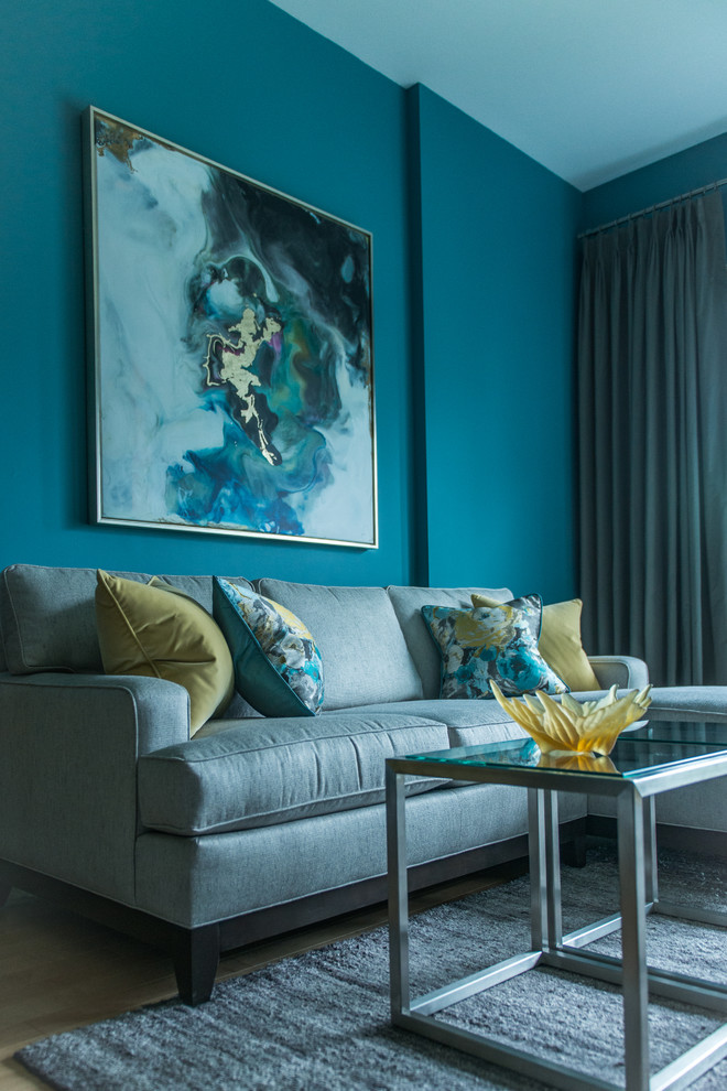 Medium sized modern grey and teal mezzanine living room in DC Metro with blue walls, light hardwood flooring, a standard fireplace, a wooden fireplace surround, a built-in media unit and yellow floors.