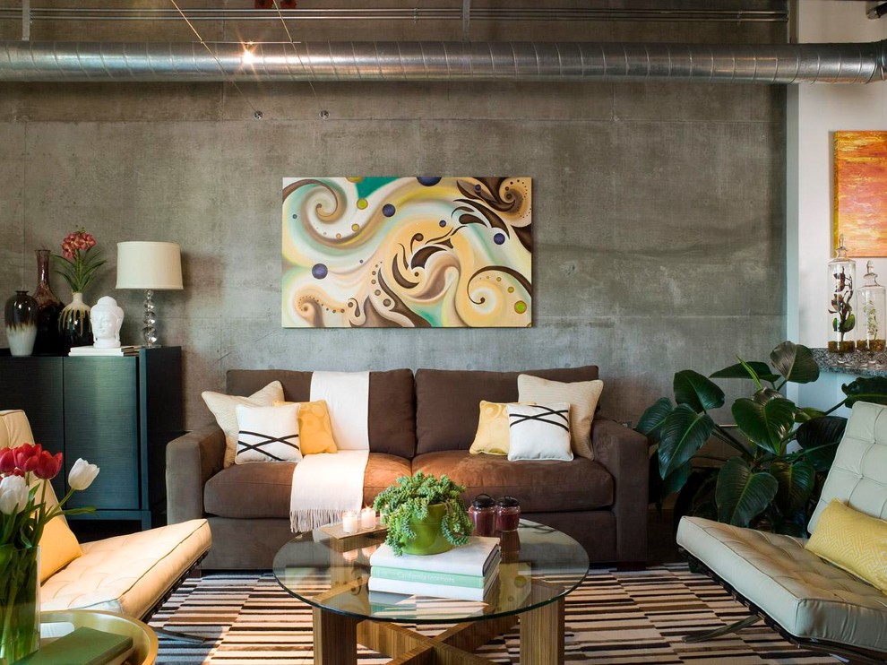 На фото: открытая гостиная комната в стиле лофт с коричневым диваном